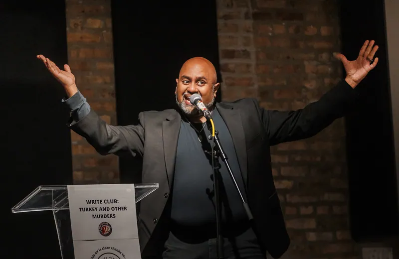 A combatant with both arms thrown wide at the microphone