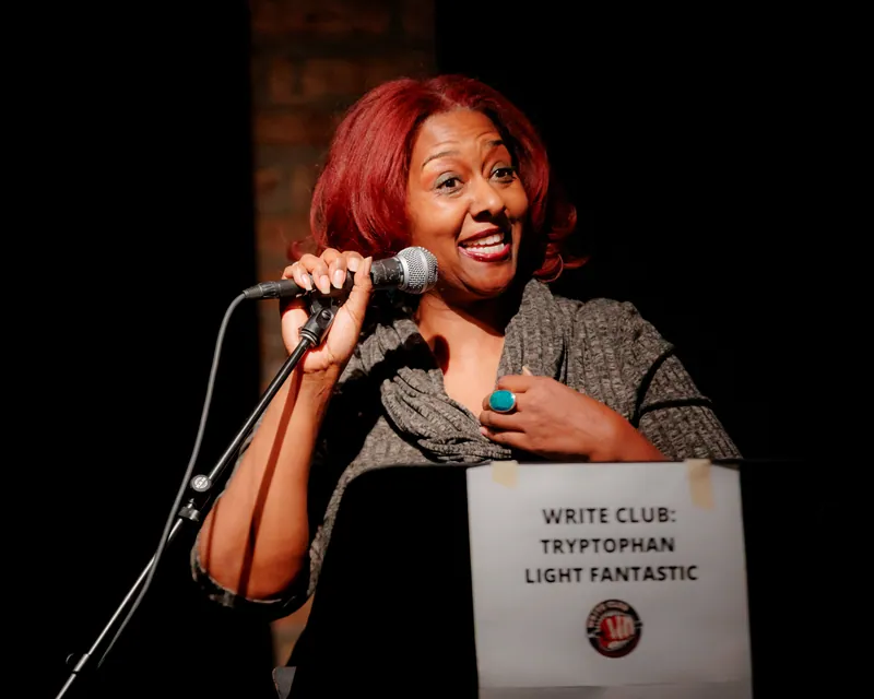 A combatant at the microphone with a hand to her chest