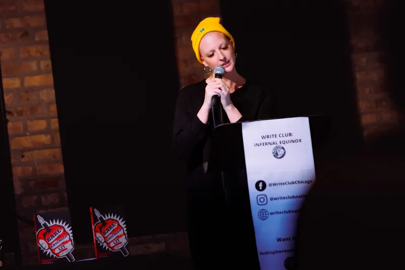 A combatant in a yellow beanie at the microphone