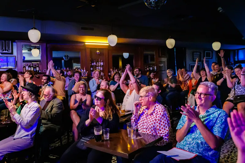 The audience mid-applause, arms up